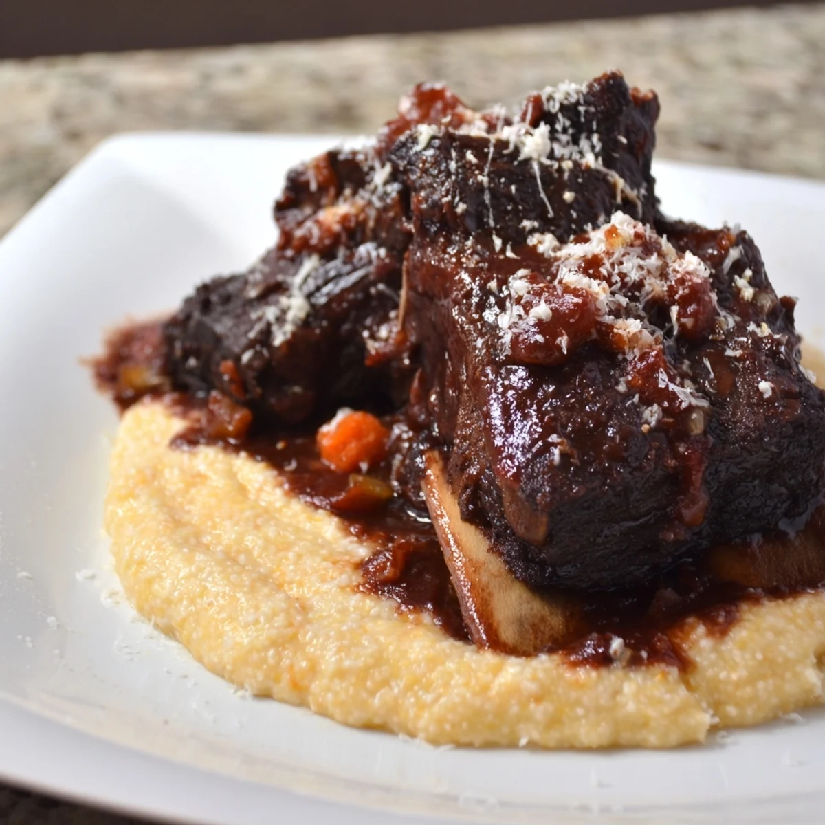 Fork-tender braised beef short ribs with velvety polenta, a comforting Italian-American dinner.