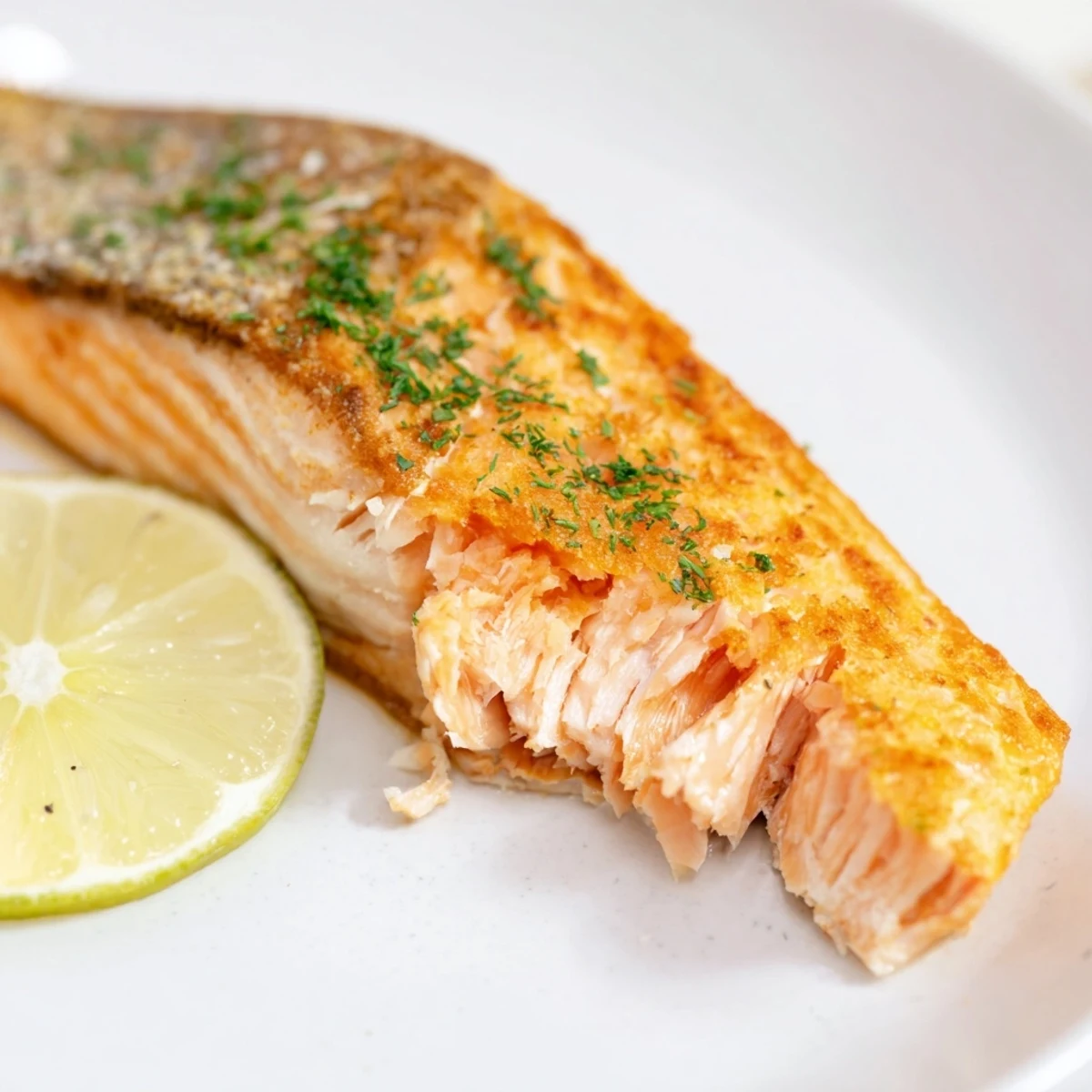 Golden brown, crispy skin on pan seared salmon, ready to be enjoyed with a lemon wedge.