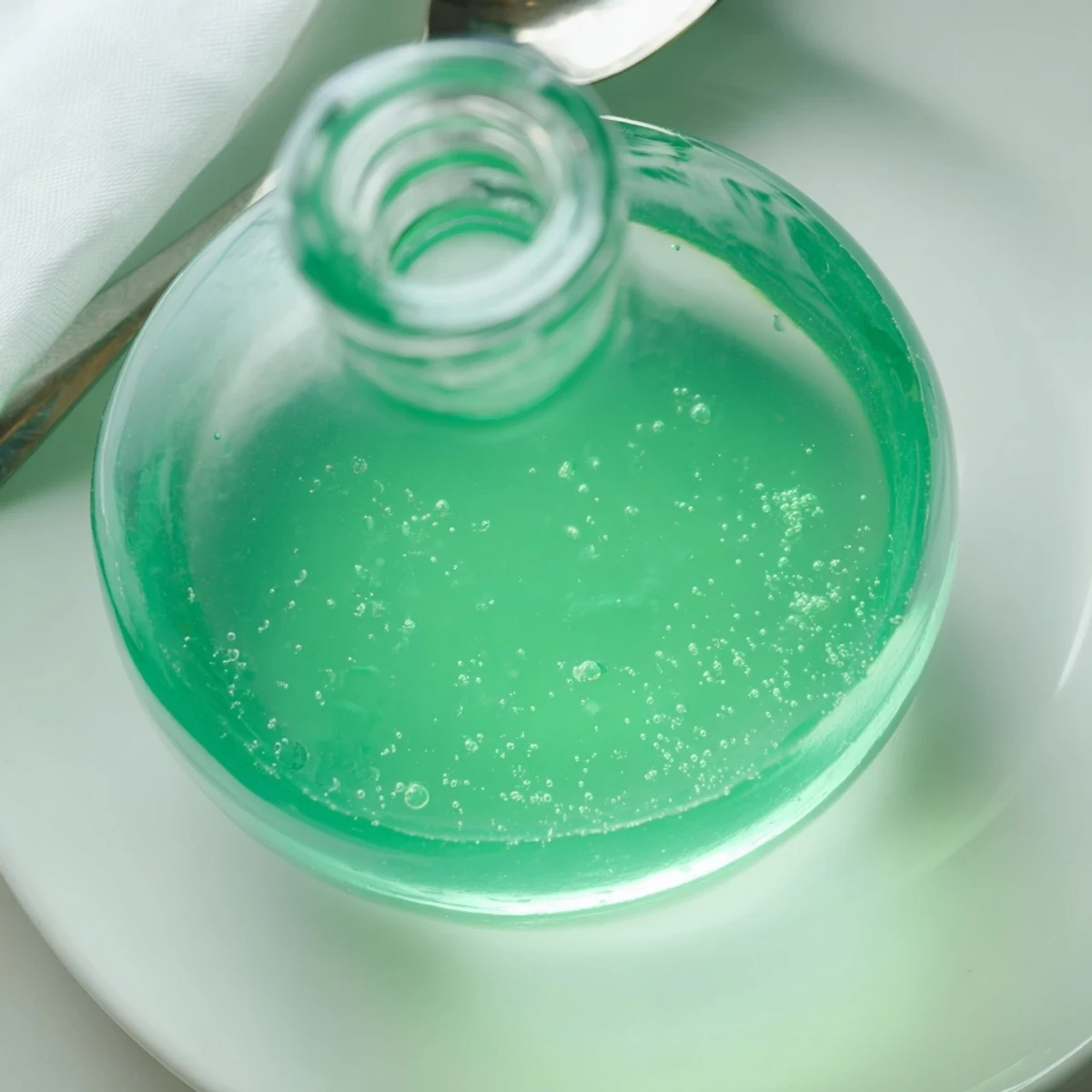 Close-up of freshly made peppermint flavor syrup in a clear jar, ready for delicious drinks.