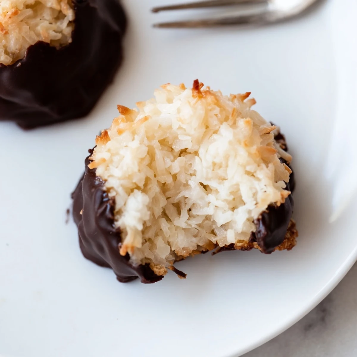 Dark chocolate-covered Chocolate Dipped Coconut Macaroons, ready to enjoy—a rich, delicious dessert.