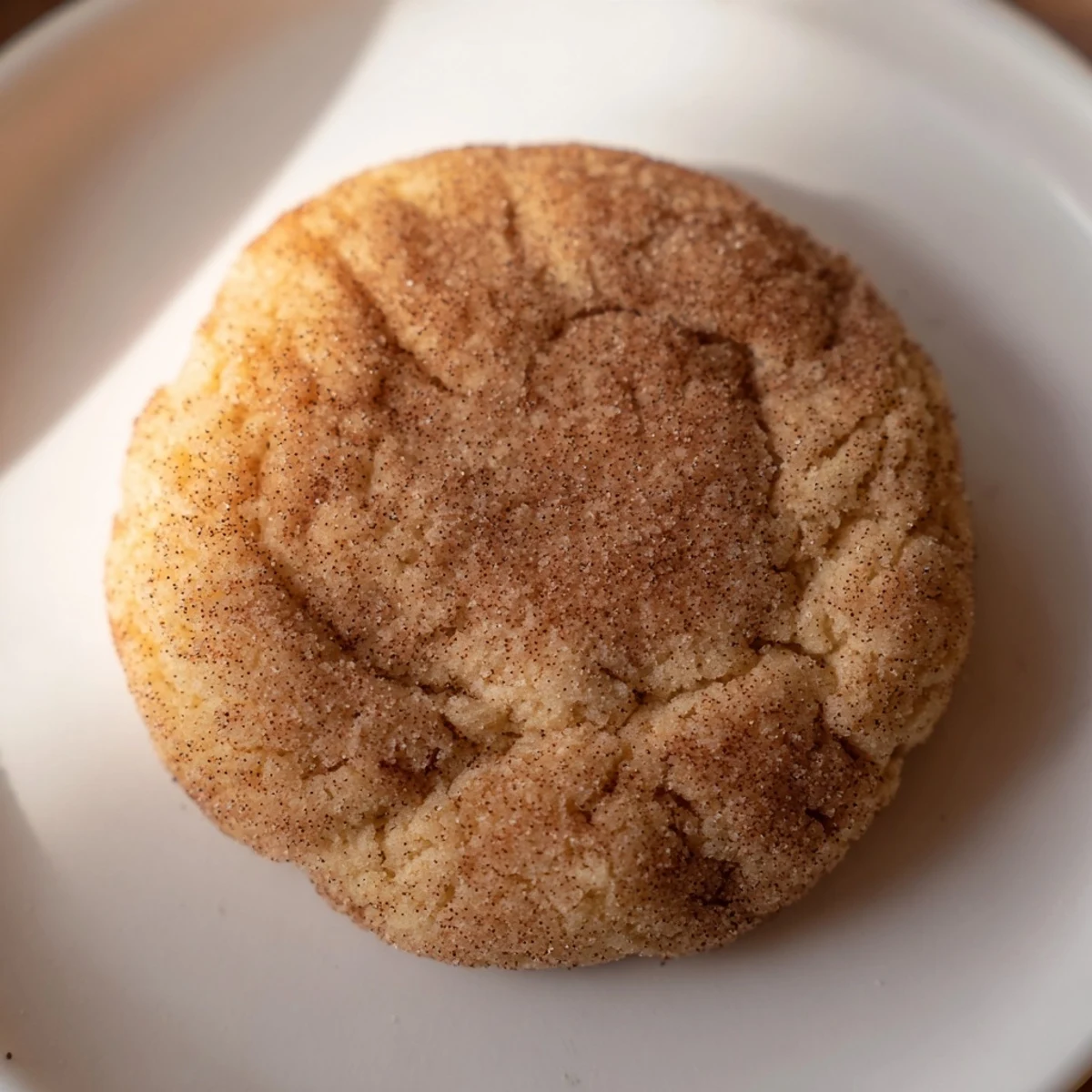 Beautifully crinkled Snickerdoodle cookies, coated in shimmering cinnamon sugar, ready to be enjoyed with milk.
