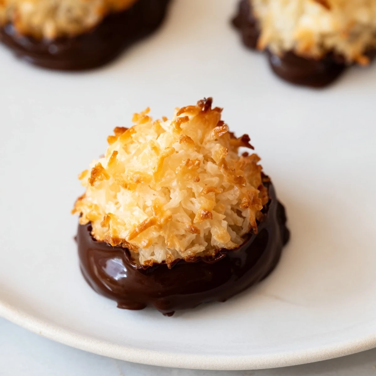 A warm stack of homemade coconut macaroons, tempting and lightly browned on a baking sheet.