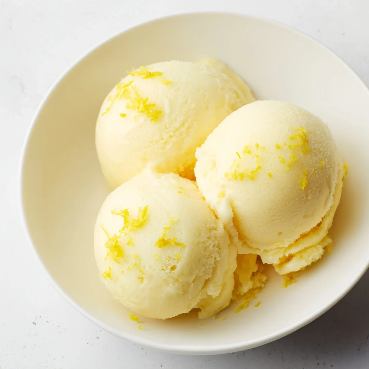 Bright yellow lemon sorbet, a refreshing dessert, beautifully served in a chilled glass.
