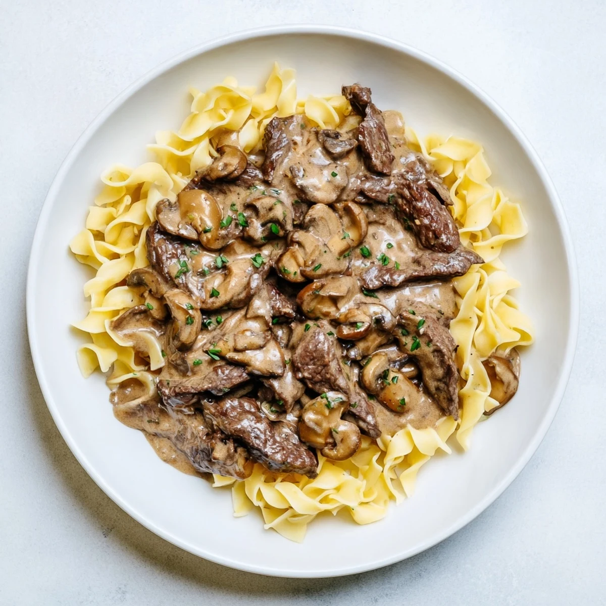 Savory beef stroganoff with tender beef and creamy mushroom gravy over fluffy egg noodles.