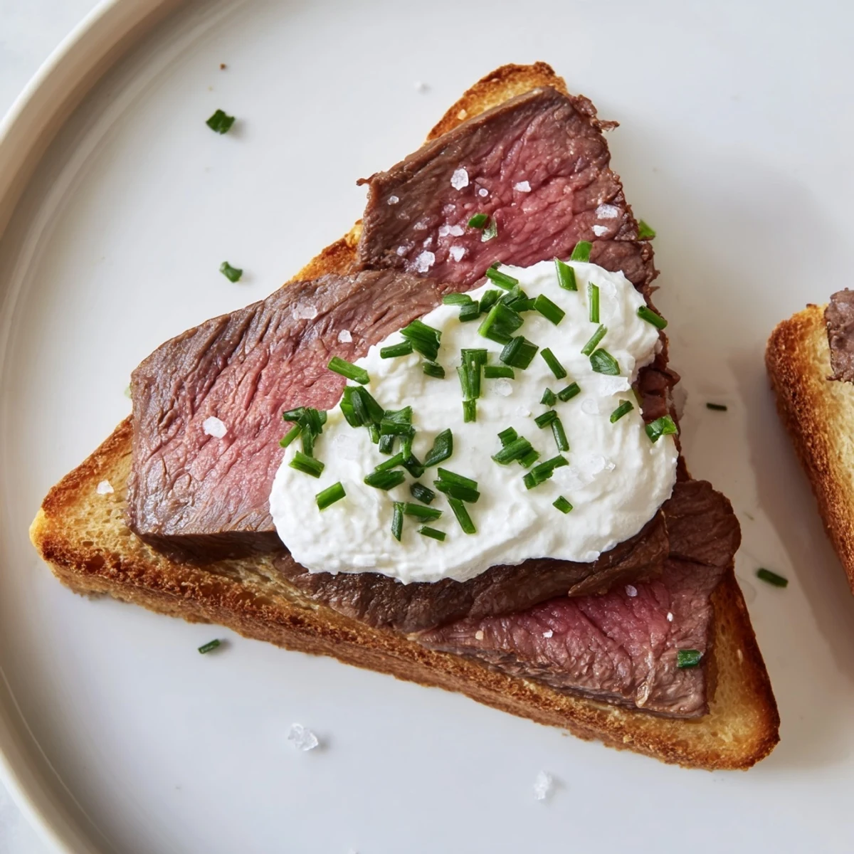 Buttery toast triangles topped with juicy beef and tangy horseradish cream, perfect for an elegant appetizer.