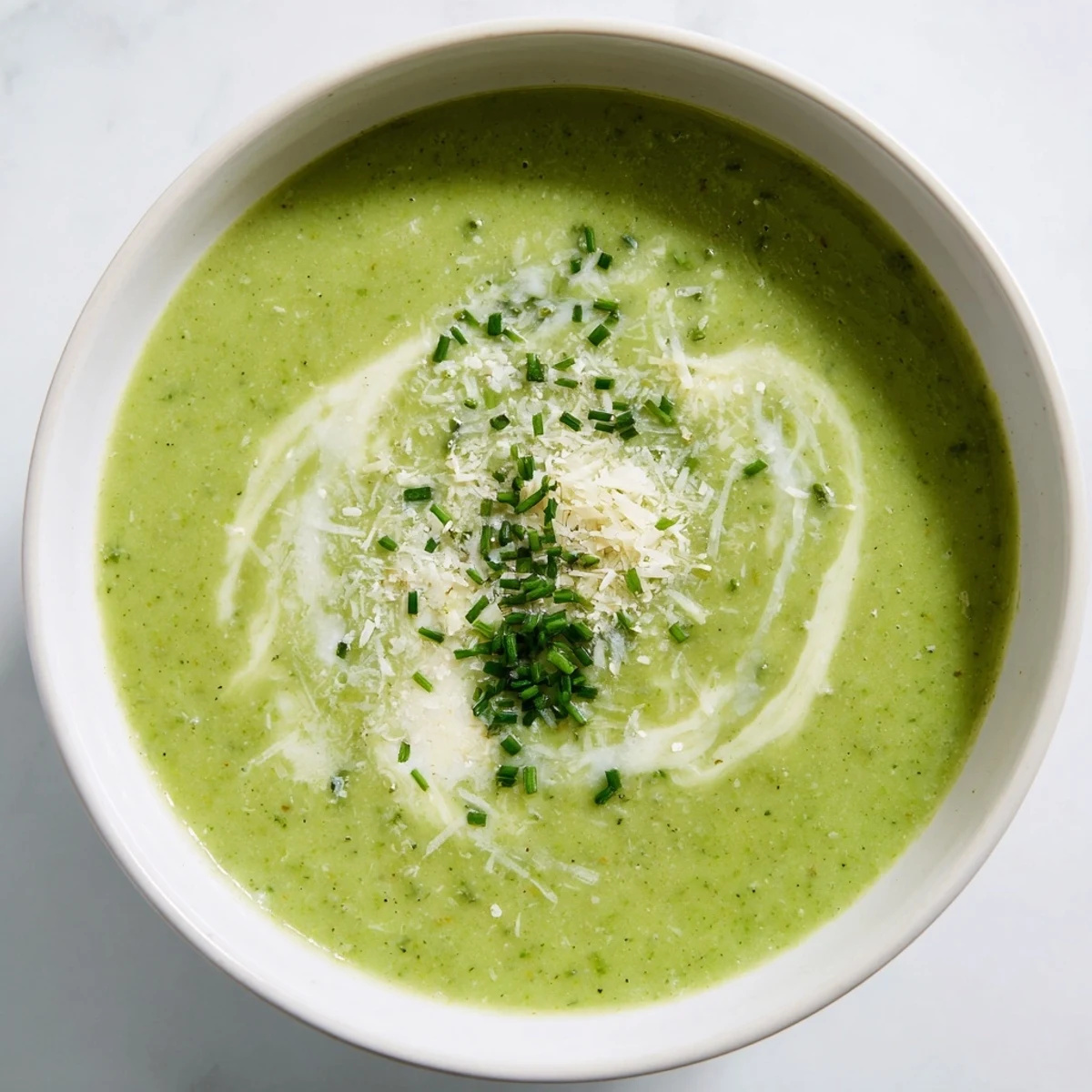 A warm bowl of Creamy Broccoli Soup garnished with herbs, paired with crusty bread on the side.