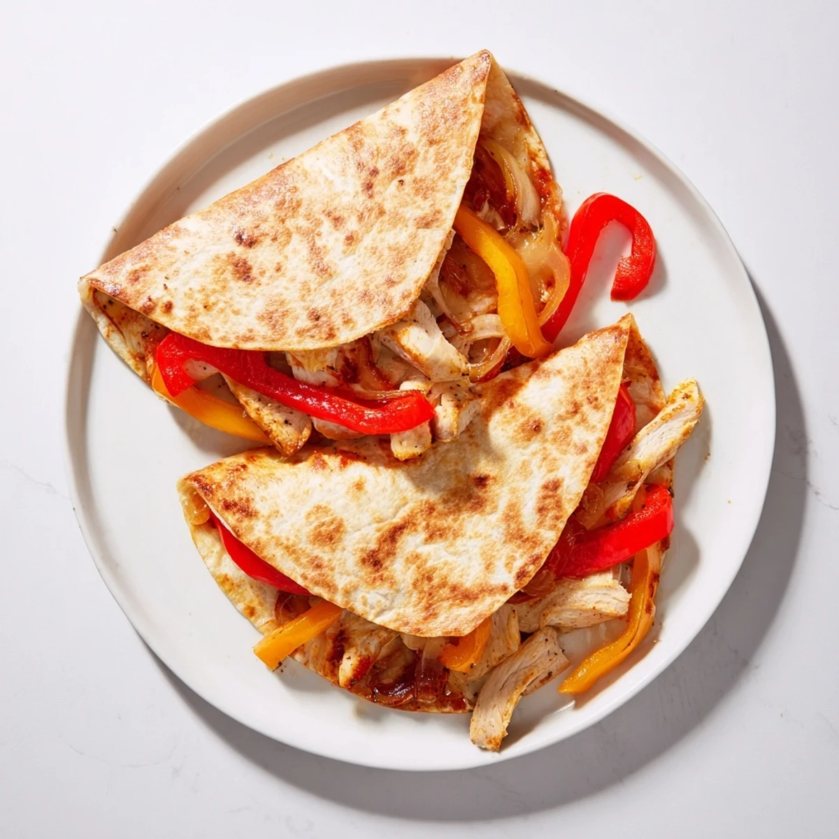 Sizzling Chicken Quesadillas with Peppers and Onions, filled with tender meat and sautéed vegetables, ready to be dipped.