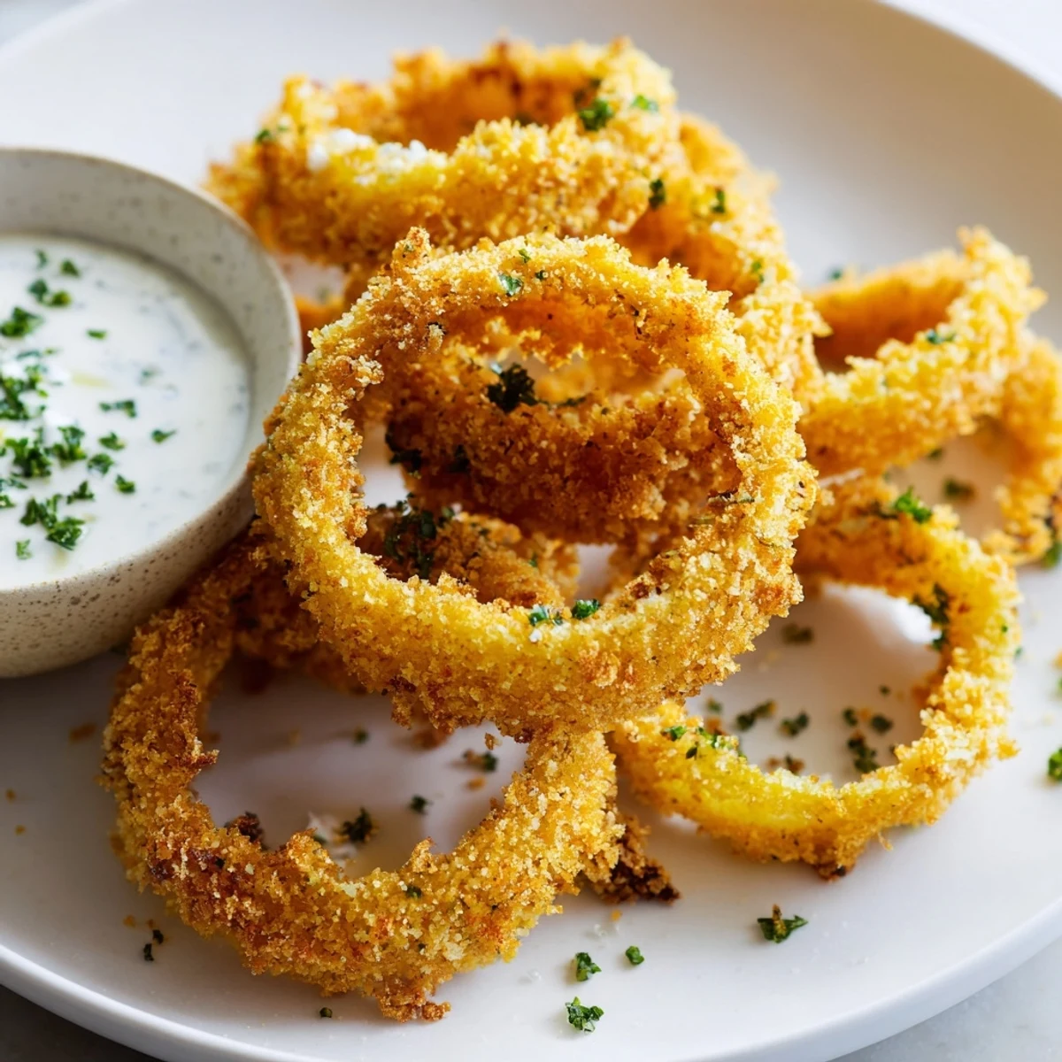 Freshly fried Touchdown Crispy Onion Rings with Ranch served warm alongside a drizzle of cool ranch dressing.