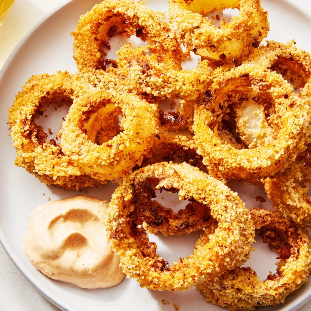 Hot, crunchy onion rings just out of the air fryer, served alongside creamy chipotle mayonnaise for dipping.  