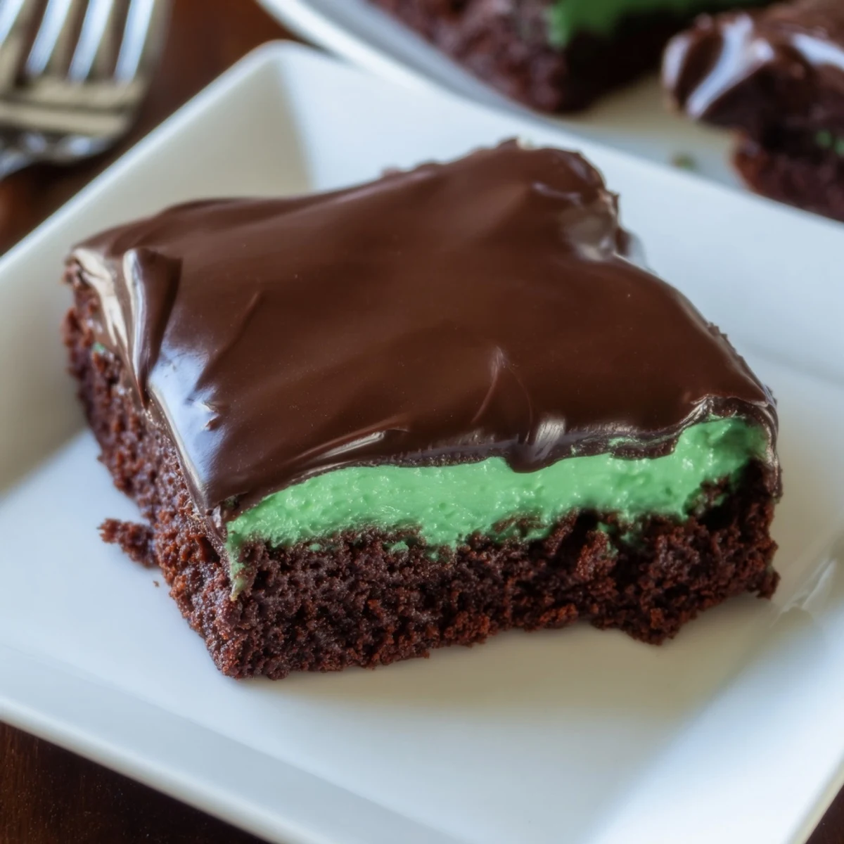 Glossy Shamrock Mint Brownies with Chocolate Ganache, stacked high with fudge layers and minty cream, ready for St. Patrick's Day parties.