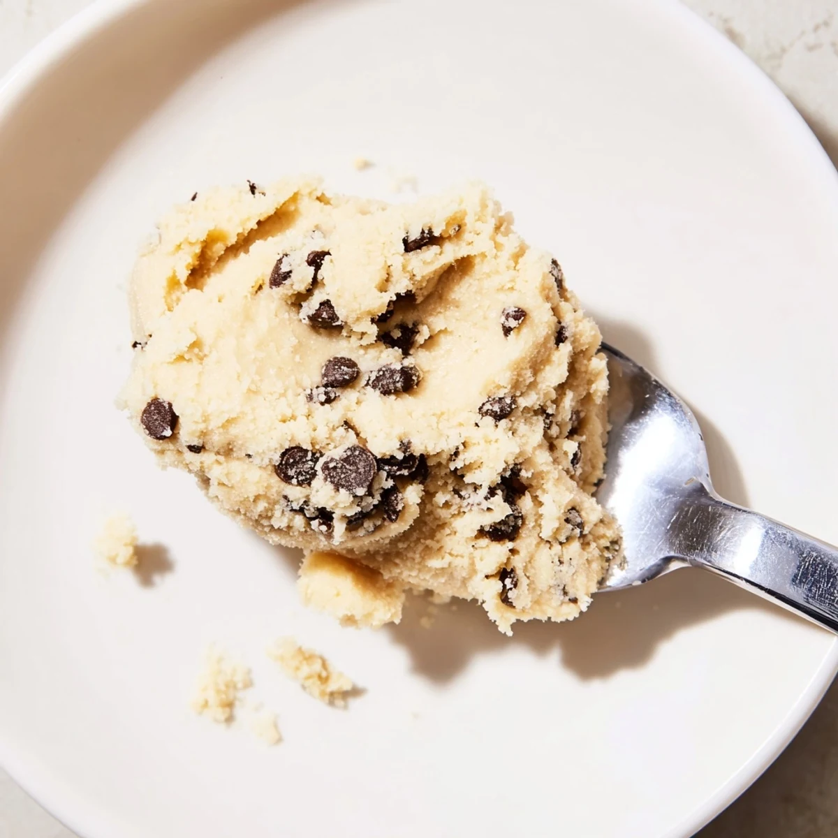 Spoonful of Edible Keto Cookie Dough held up, highlighting its low-carb, gluten-free ingredients and rich vanilla aroma.