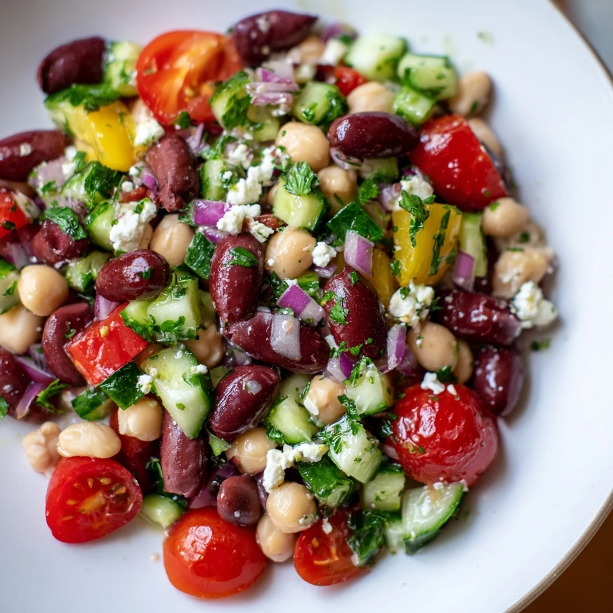 Fresh Mediterranean Dense Bean Salad with red onion, cucumber, and olives, tossed in lemon-herb dressing.