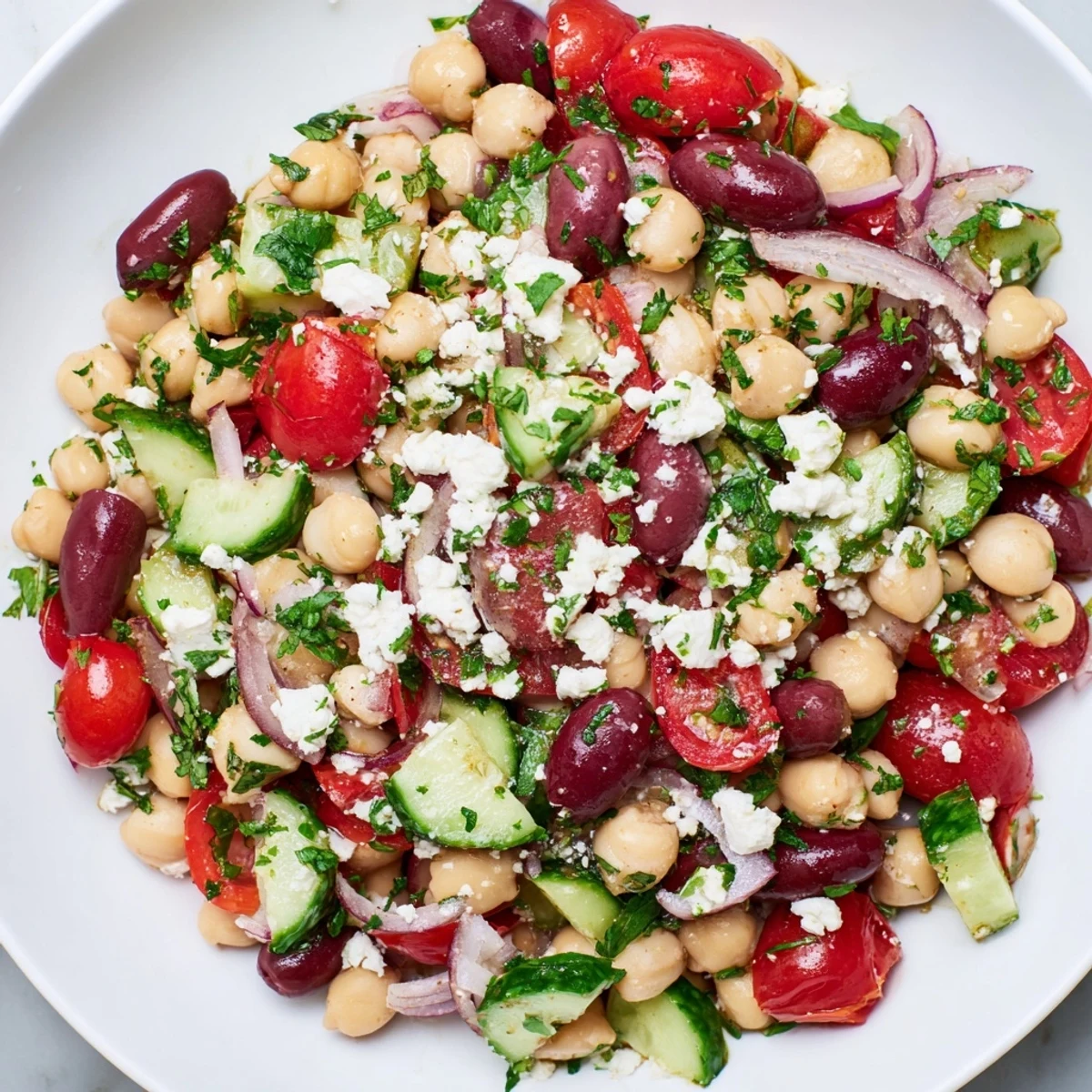 Colorful Mediterranean Dense Bean Salad served as a side dish, featuring bright veggies and crumbled cheese.