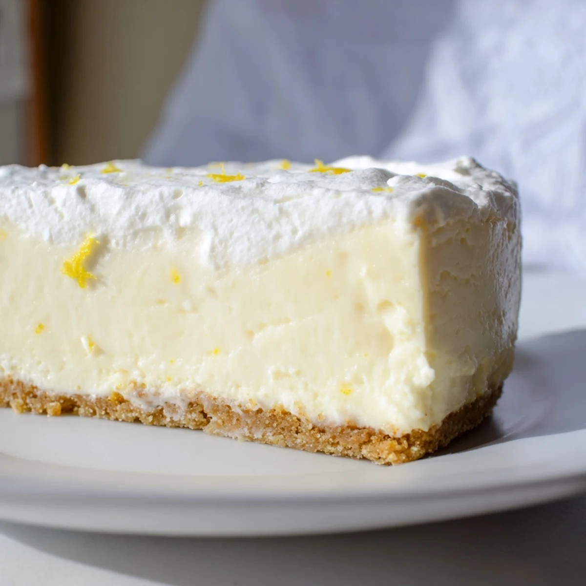 A close-up of Rich Greek Yogurt Cheesecake with a smooth, creamy texture and graham cracker crust, served on a dessert plate.