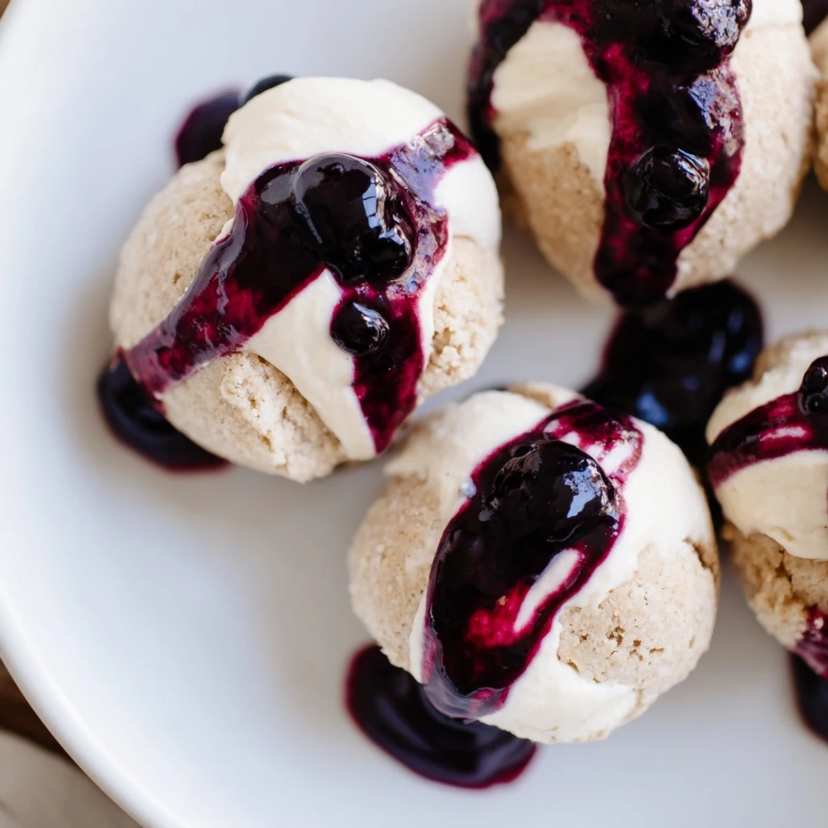 Close-up of homemade Blueberry Cheesecake Protein Bites in a silicone mold, highlighting the almond flour base and fresh blueberry garnish.