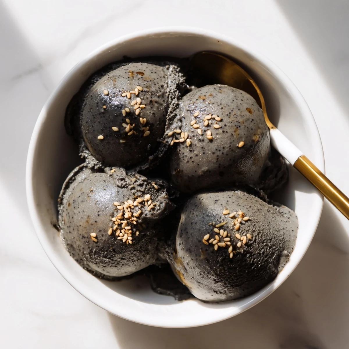Rich homemade Toasted Black Sesame Ice Cream in a rustic ceramic dish, highlighting its texture.
