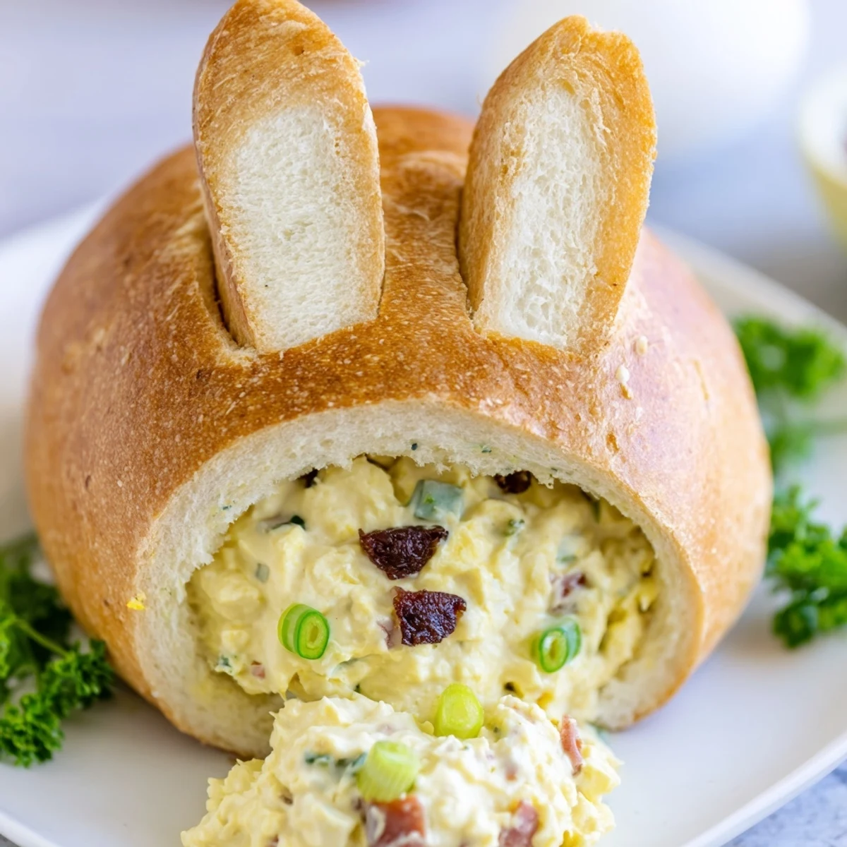 A close-up of the Easter Bunny Cob with Egg Salad shows the savory egg salad filling with celery and bacon bits.