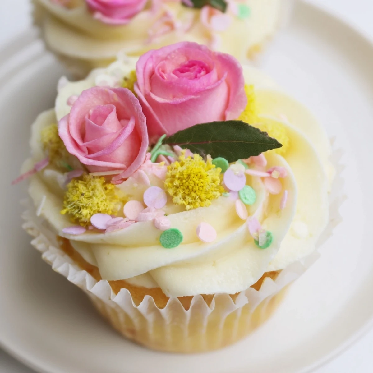 These Baby In Bloom Cupcakes feature pink, yellow, and green floral buttercream swirls on a soft vanilla cupcake.