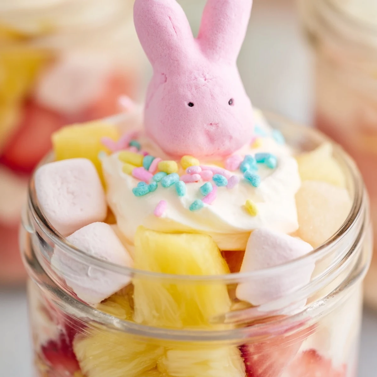 Strawberry and lemon gelatin cubes mixed with fresh fruit and fluffy cream cheese filling inside a 6-ounce serving jar.