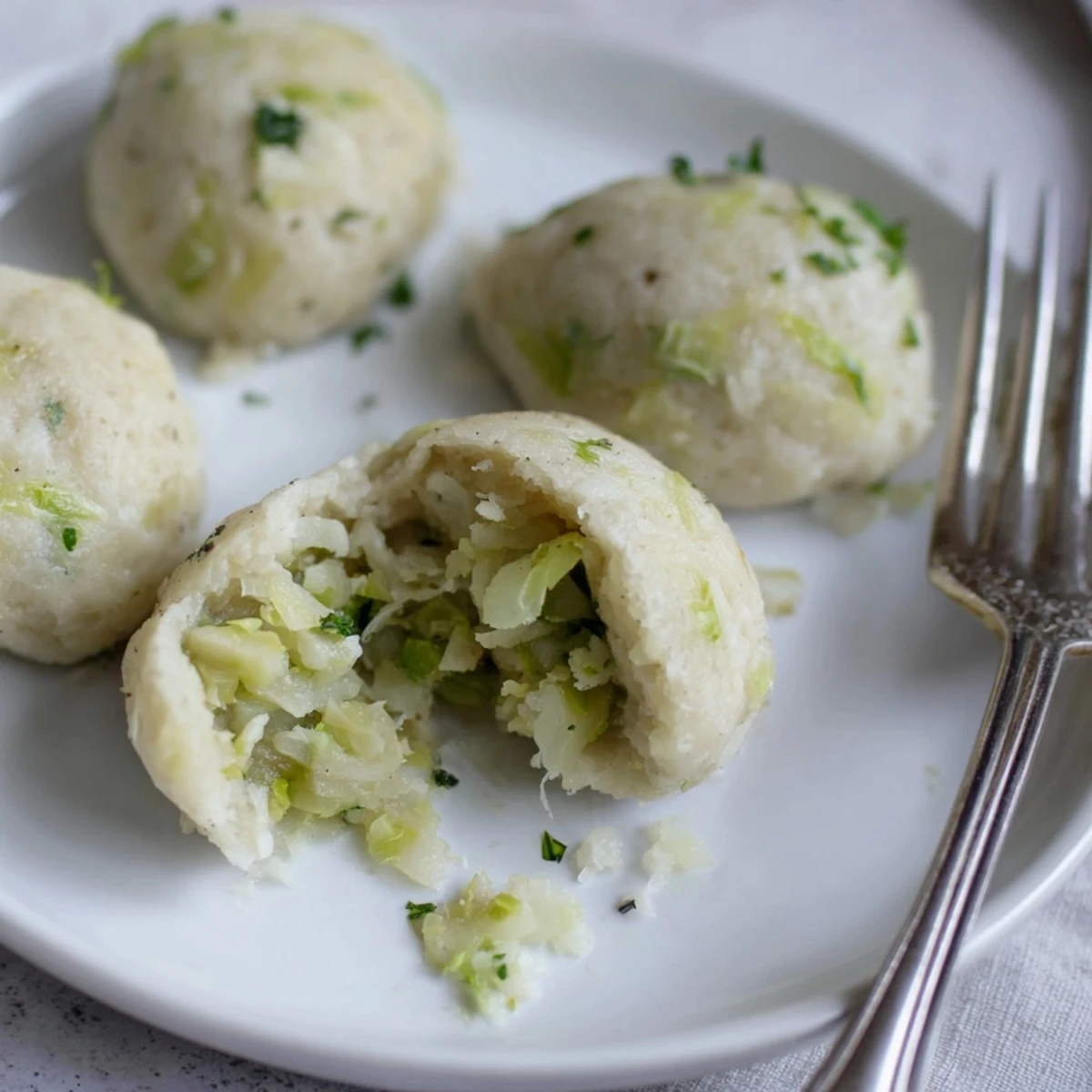 Steamed German Cabbage Dumplings in a ceramic bowl with parsley garnish.