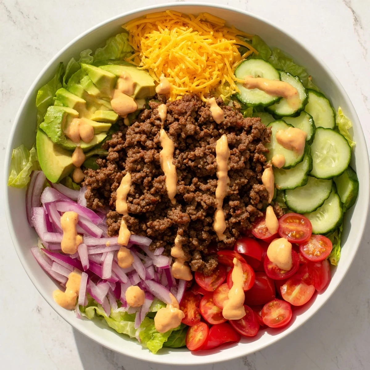 Serving Burger Bowls garnished with shredded cheddar and fresh toppings for a low carb gluten free weeknight dinner.