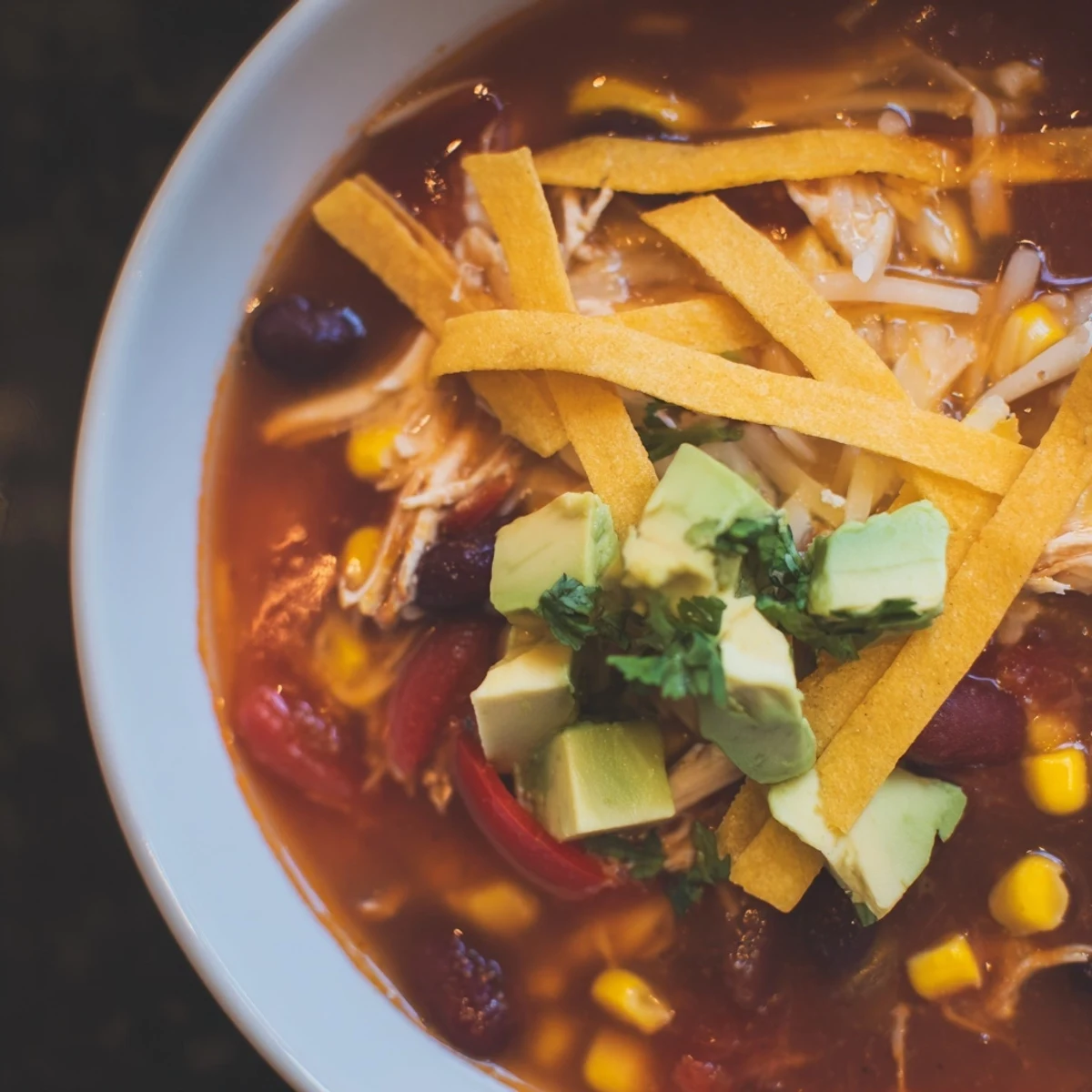 Steaming Classic Chicken Tortilla Soup featuring tender chicken, black beans, and colorful vegetables in rich broth.