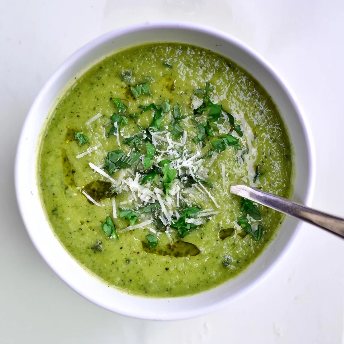 Steamy bowl of homemade Italian broccoli soup topped with grated Parmesan and chopped parsley garnish