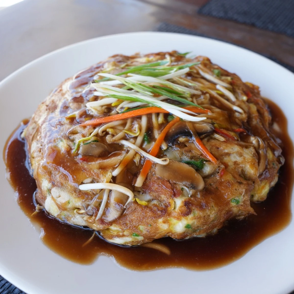 Golden crispy Egg Foo Young patties topped with rich brown gravy and fresh green onions