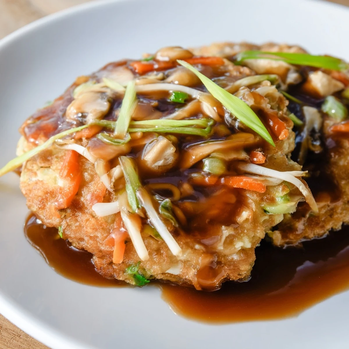 Fluffy vegetable-packed Egg Foo Young fried until golden brown and served over steamed white rice