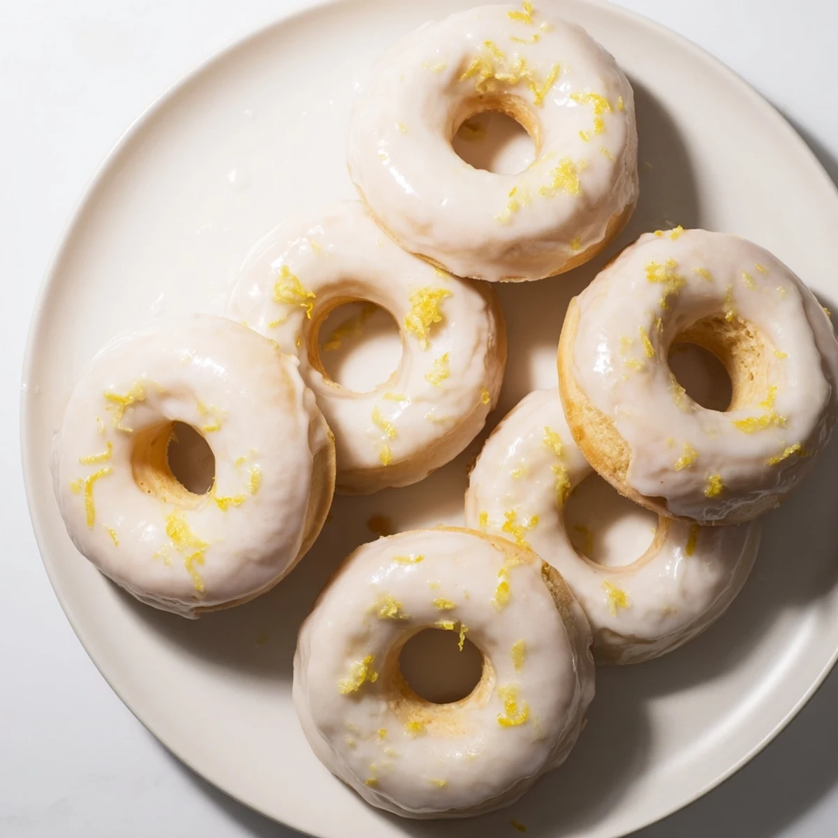 Stack of fluffy lemon mochi donuts with sweet tangy glaze on wooden board