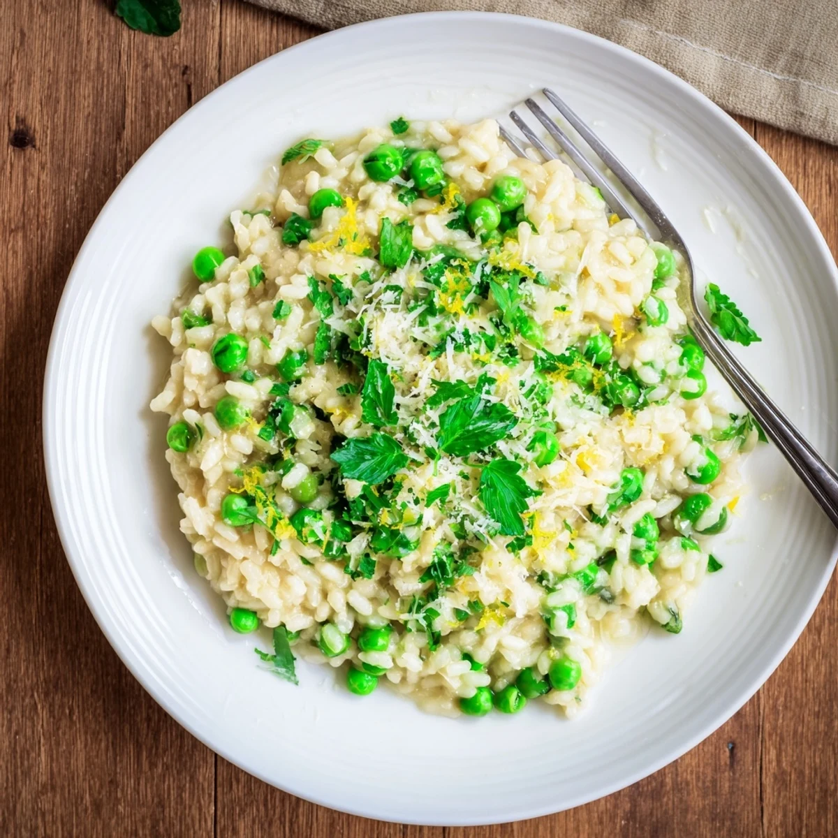 Spoonful of creamy spring pea risotto studded with tender sweet peas and freshly grated Parmesan cheese