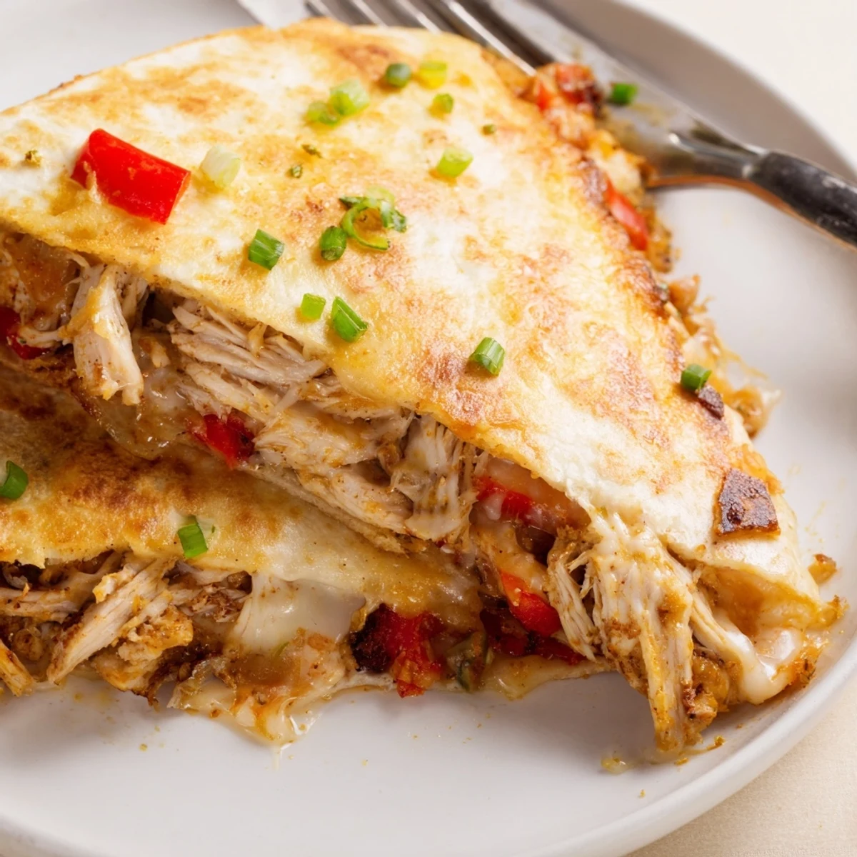 Cut wedges of easy baked chicken and cheese quesadillas showing tender spiced chicken filling inside