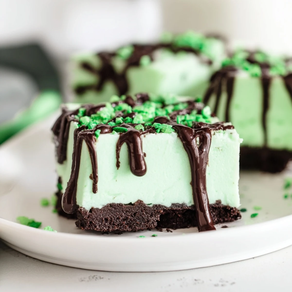 Decadent St. Patricks Irish Mint Cheesecake Fudge Squares with rich chocolate cookie crust