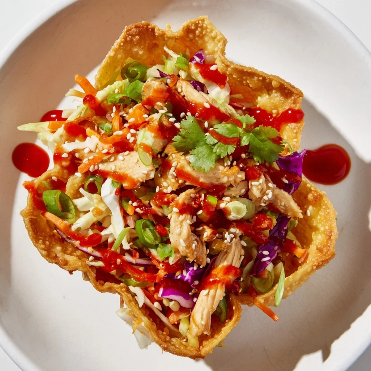 Fusion appetizer featuring baked wonton shells filled with seasoned chicken and tangy cabbage slaw