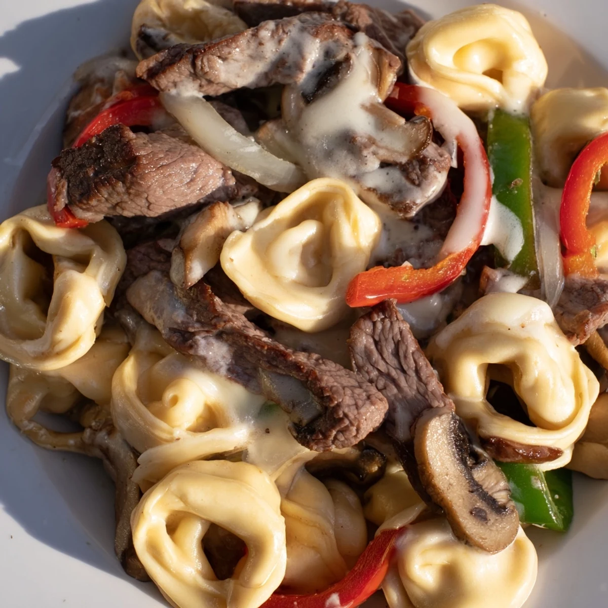 Creamy Crock Pot cheesesteak tortellini loaded with tender beef, peppers, and melted provolone in a rich slow-cooked sauce