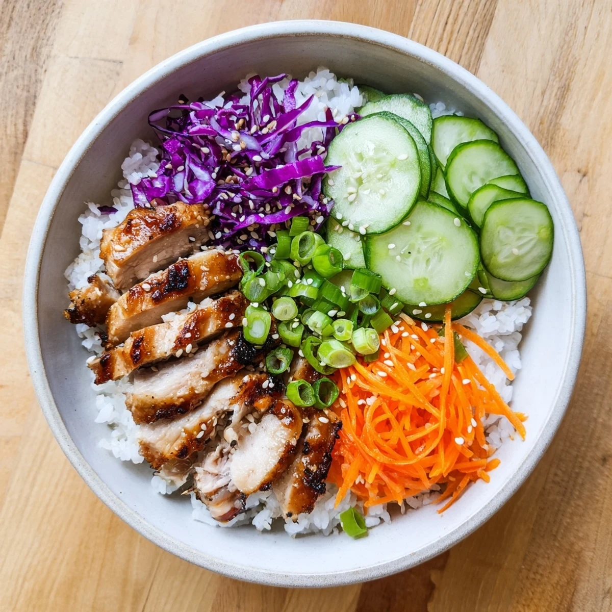 Savory charred chicken thighs in sweet-spicy marinade atop a colorful grain bowl with fresh vegetables