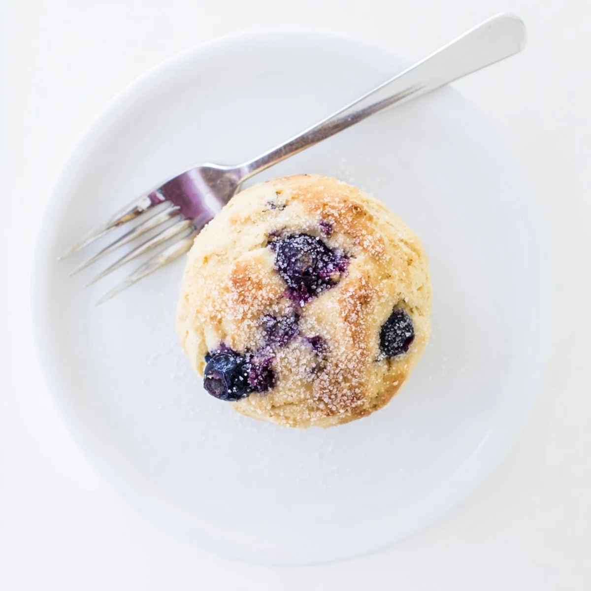 Freshly baked blueberry biscuits arranged on a wire rack showing golden brown crusts and purple berry pockets