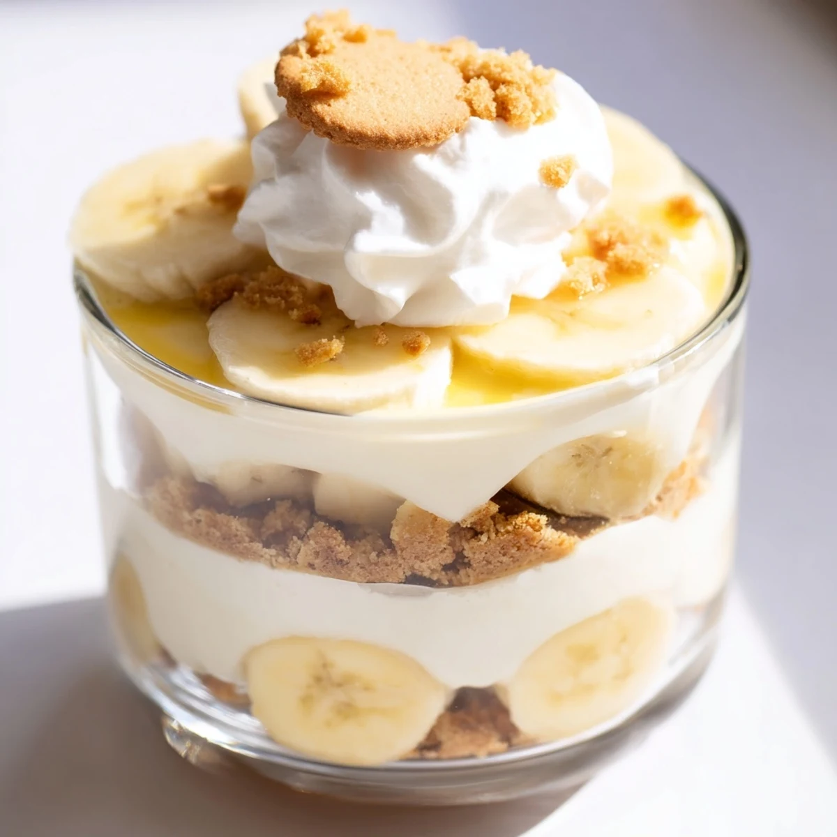 No bake banana pudding cheesecake cups featuring silky layers topped with golden cookie crumble