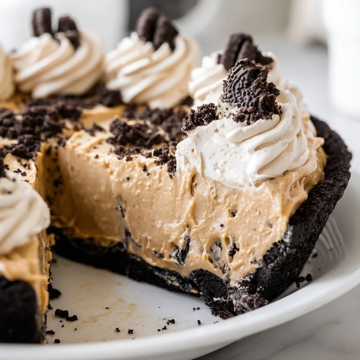Sliced peanut butter Oreo pie with glossy chocolate drizzle on a white dessert plate