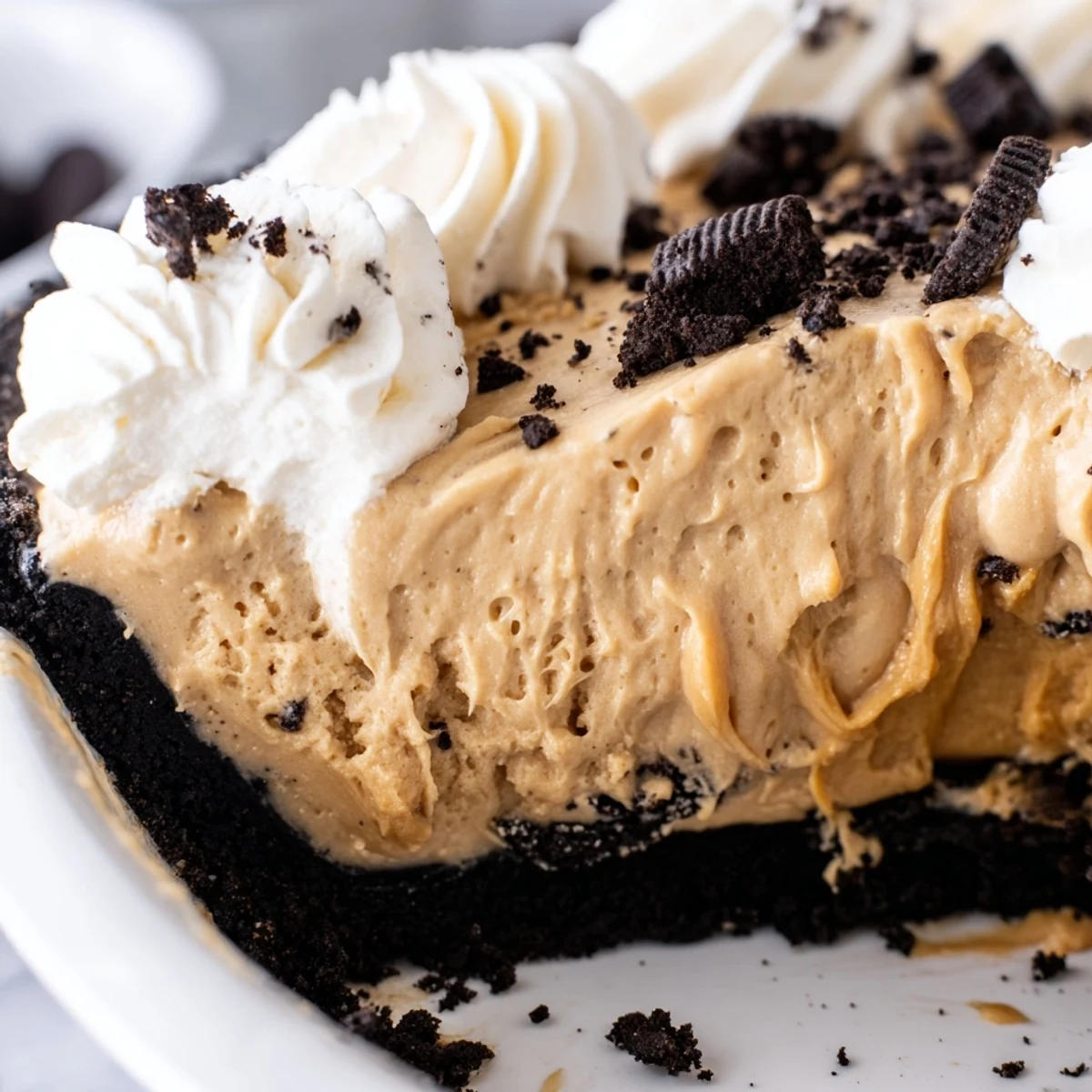 Velvety peanut butter filling in dark Oreo crust crowned with light airy whipped cream peaks