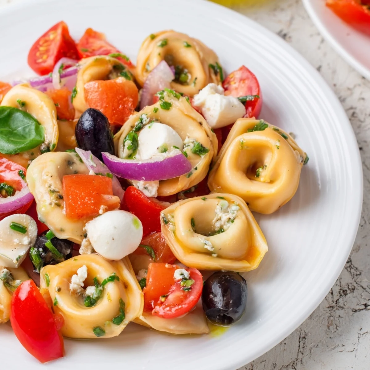Creamy cheese tortellini pasta salad tossed with crisp vegetables and mozzarella, ready for picnics