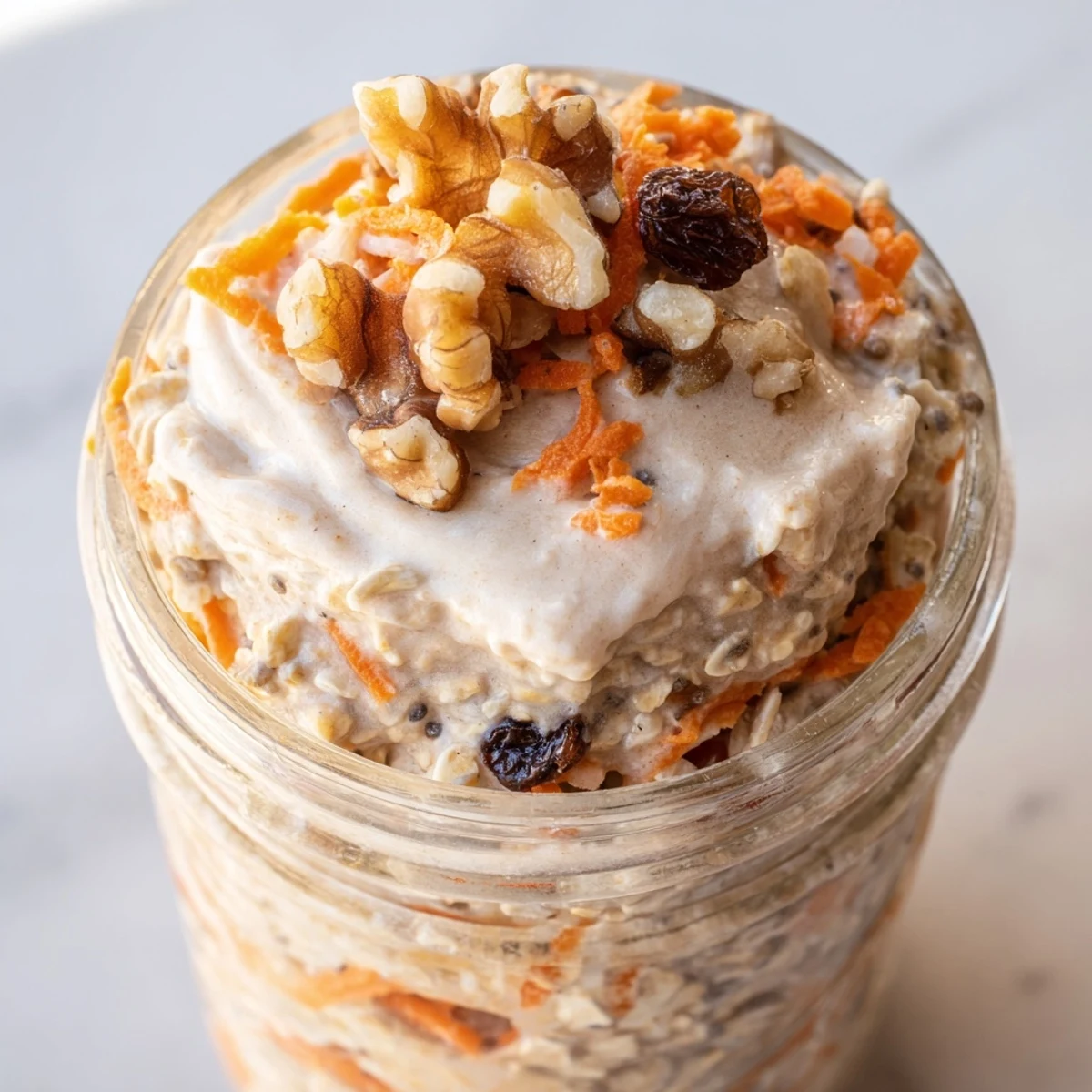 Spoonful of Carrot Cake Overnight Oats revealing tender grated carrot and plump raisins in a bowl