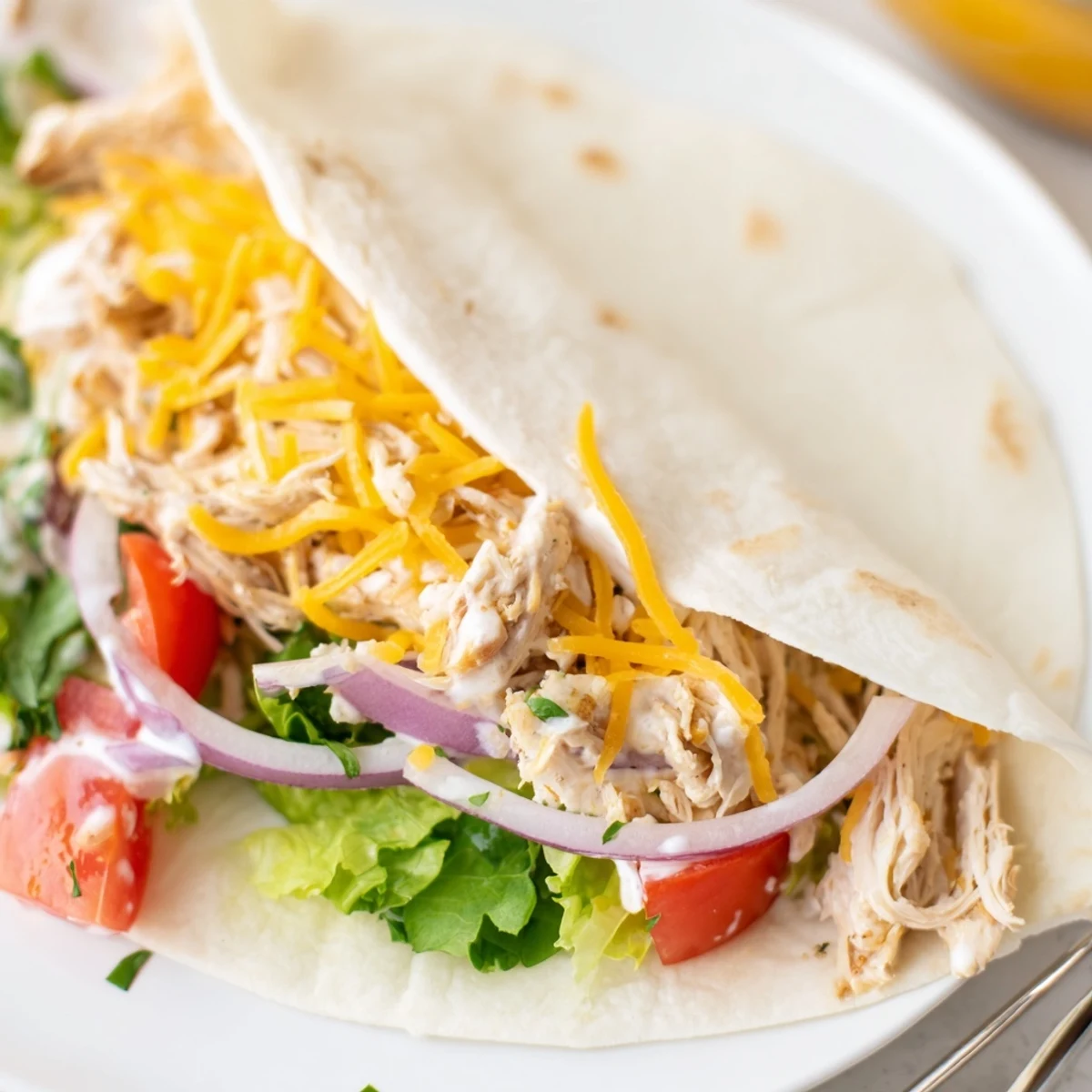 Warm Cheesy Garlic Chicken Wraps sliced in halves, oozing cheese, ready to serve.