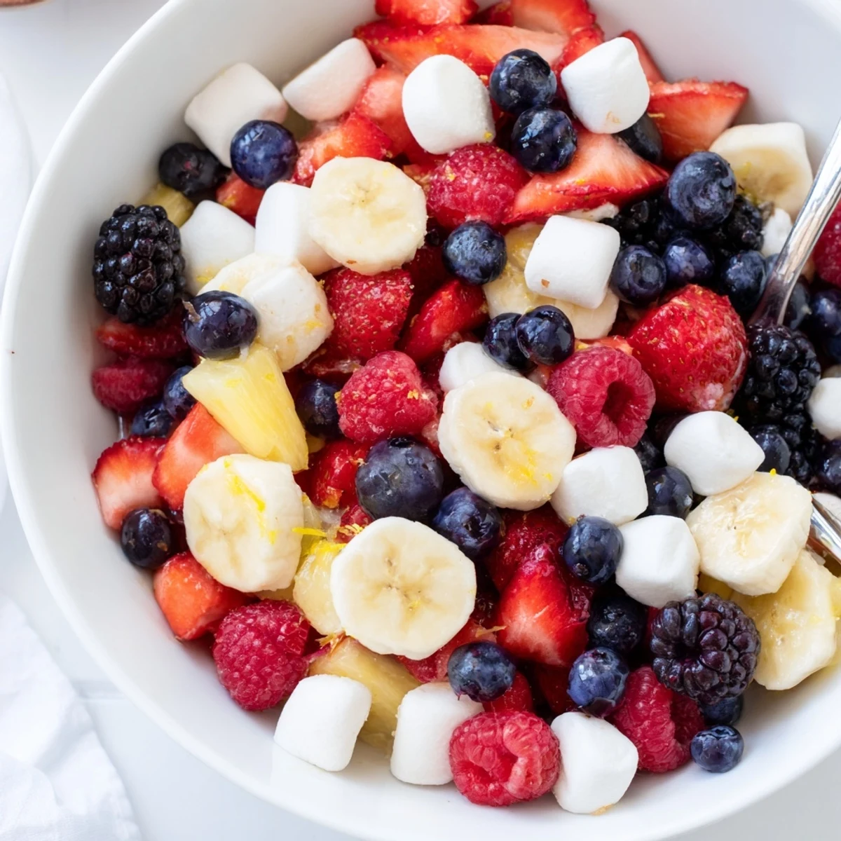 Red White And Blue Fruit Salad with juicy berries, pineapple, and lime drizzle