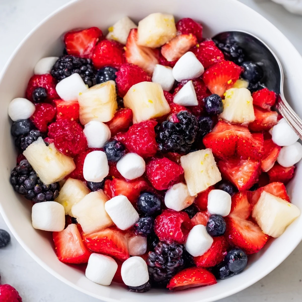 Bright Red White And Blue Fruit Salad topped with pineapple, banana, and zesty lime