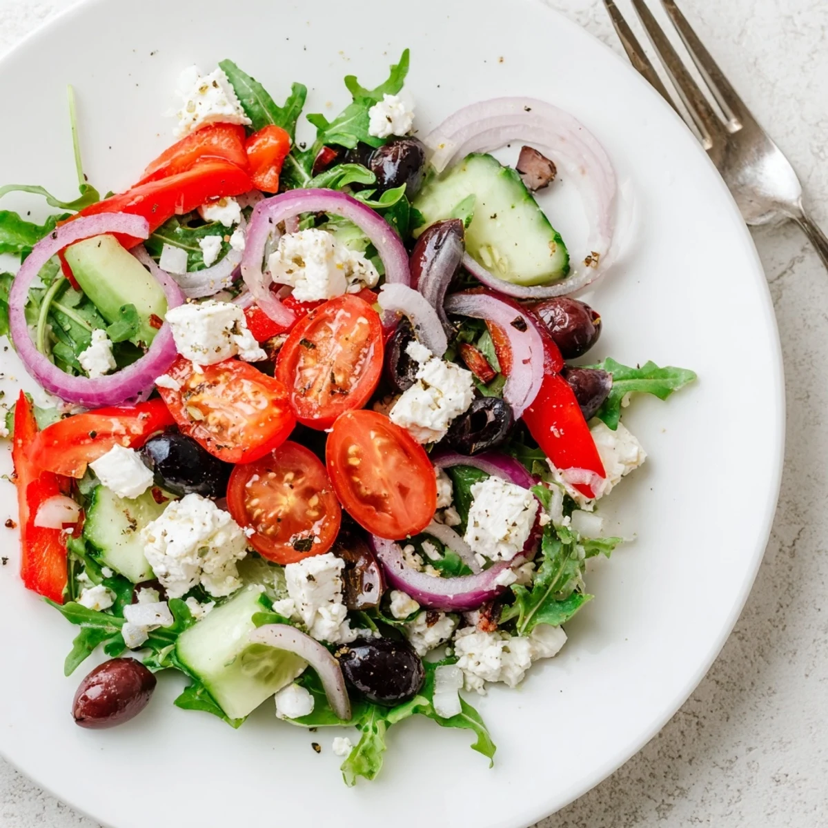 Fresh Salad Recipe in a bowl tossed with peppery arugula, crumbled feta