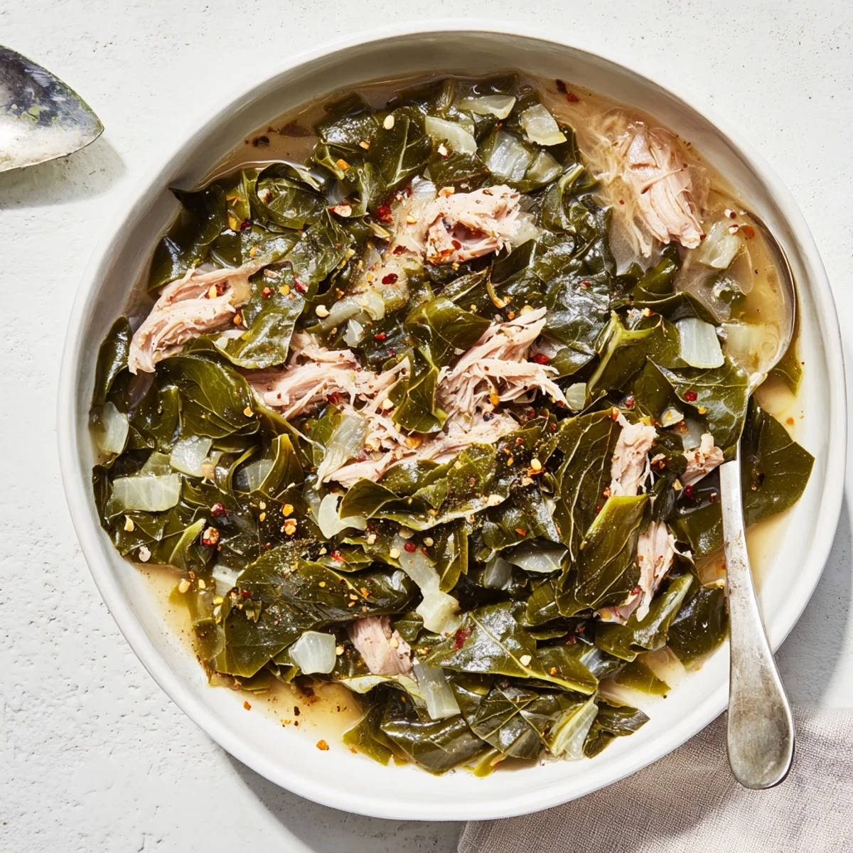 Vibrant green collard greens slow-simmered with aromatic onions in a rich broth