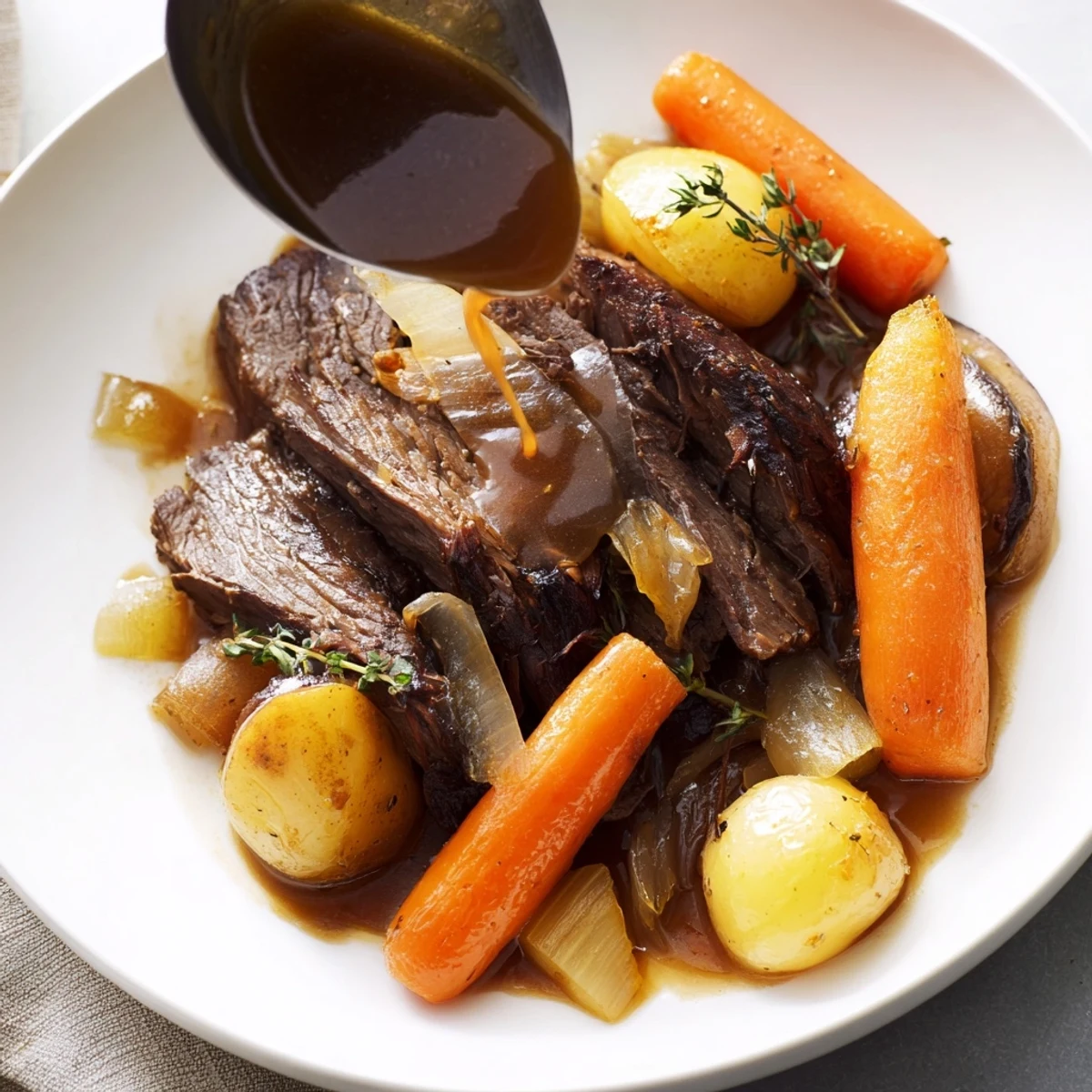 Flavorful braised beef chuck roast plated with baby potatoes and fresh rosemary sprigs