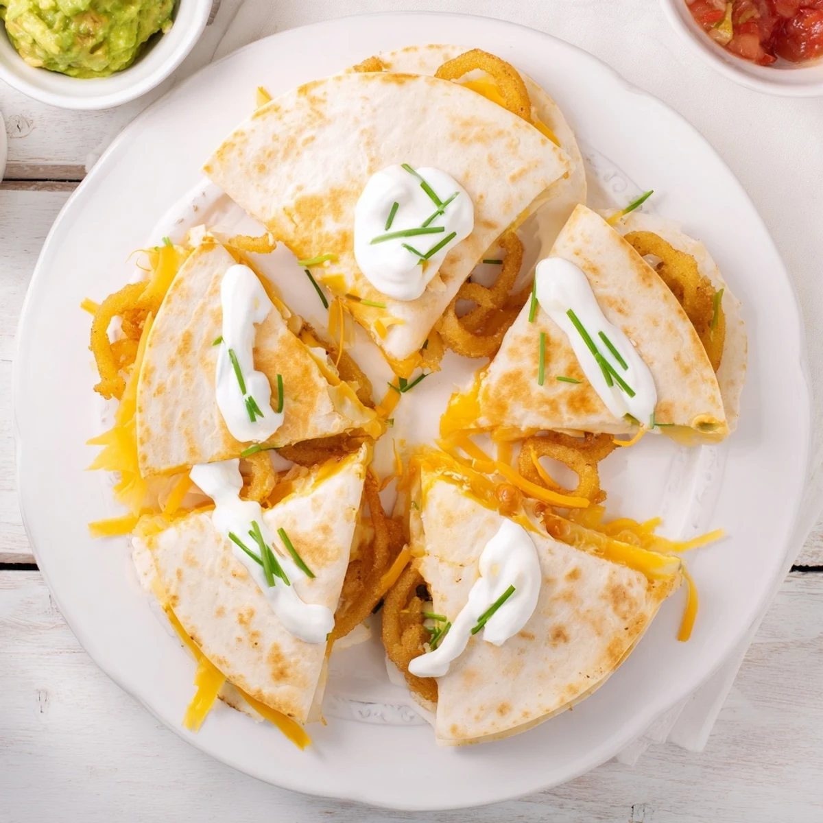 Sliced Tex-Mex quesadilla revealing crispy fried onion rings inside gooey layered cheese filling