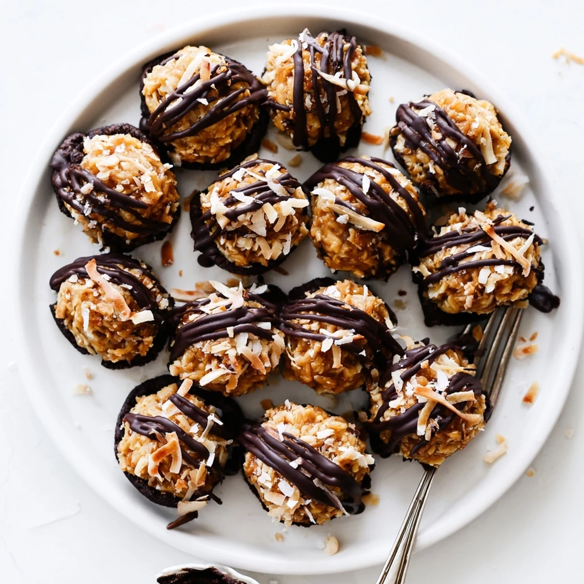 Close up of chocolate dipped no bake Samoa bites showing caramel coconut layers and dark chocolate coating